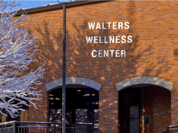 Front view of the outside of Walters Wellness Center during a snowy day