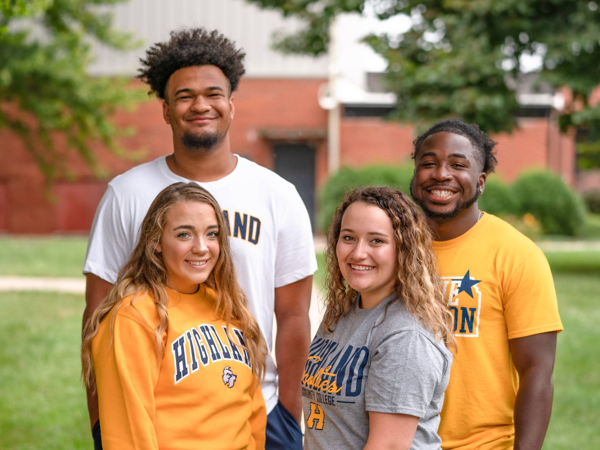 Four students outside, grouped together to pose for a photo