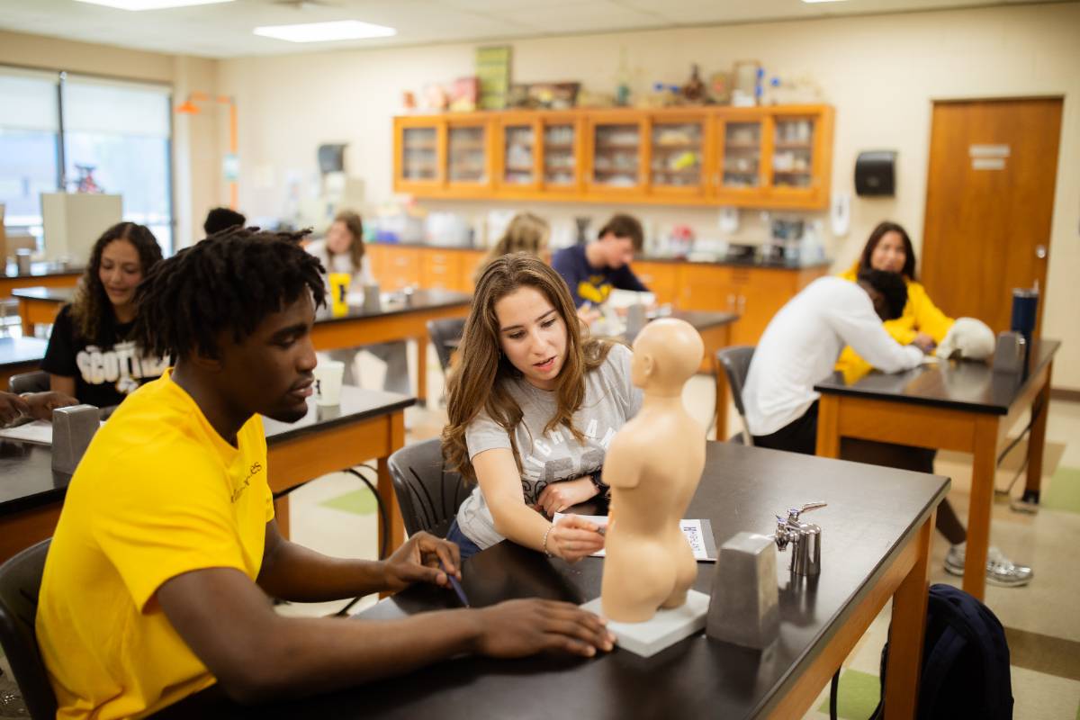 Group of students in a science classroom reviewing artifacts
