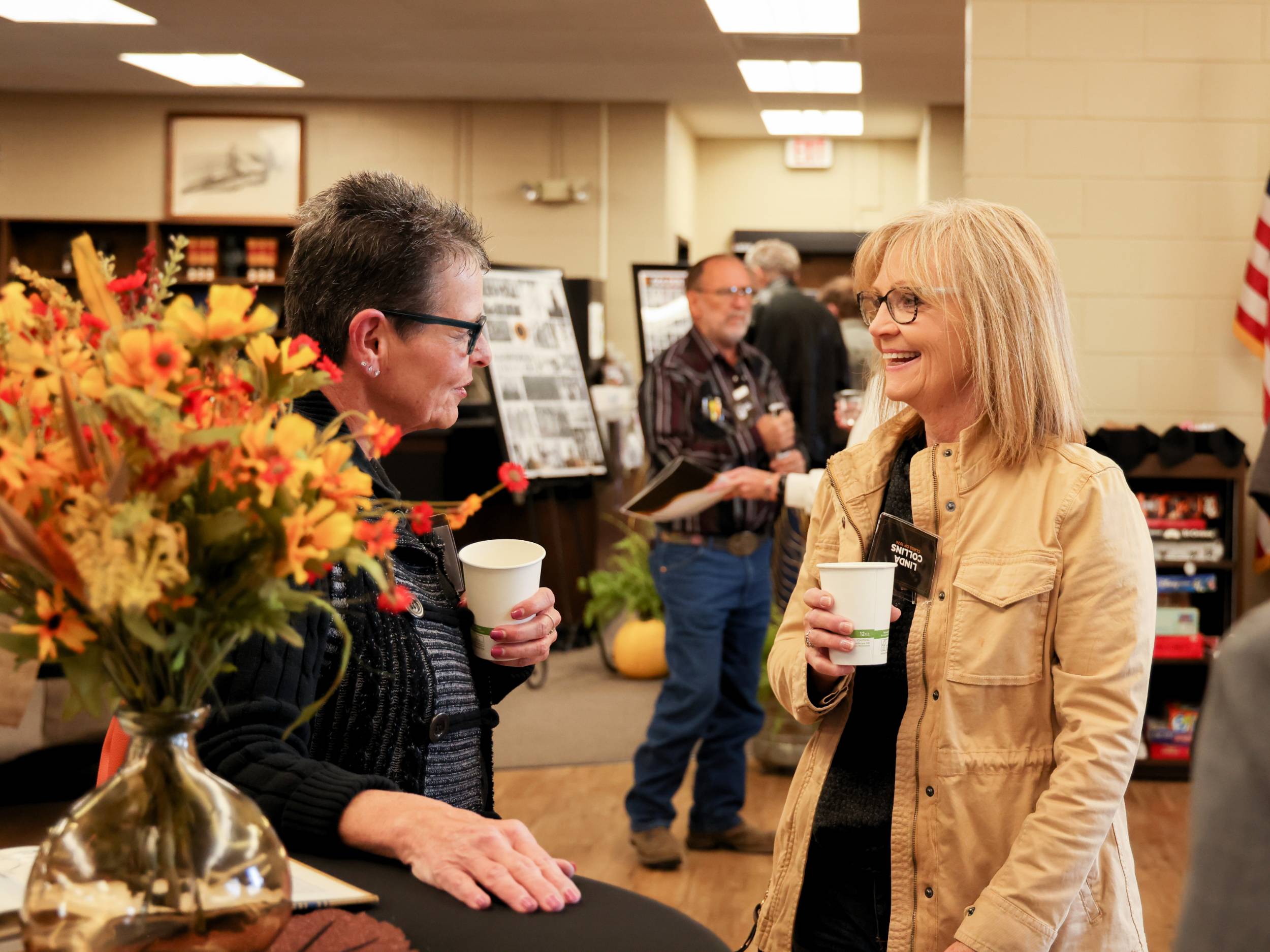 Linda Collins greeting another alumni member at an event.