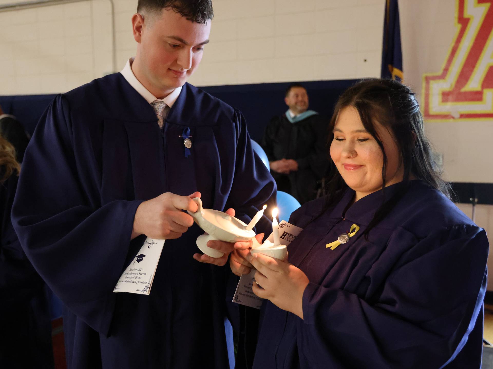 Two students light candle during the nursing pinning ceremony in 2024. 