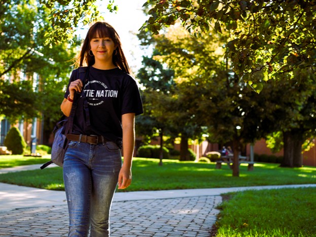 Student walking outside carrying a backpack.